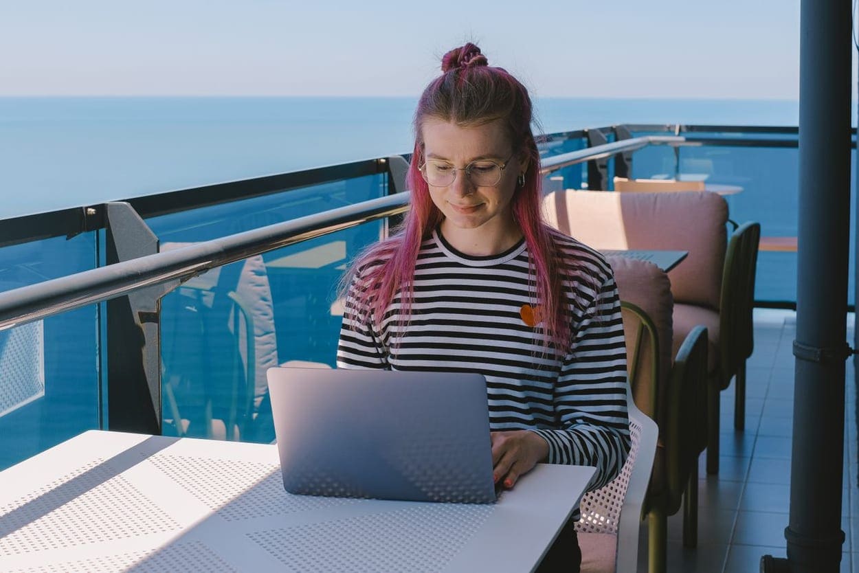 Someone working on a laptop with a sea view (illustrative photograph)