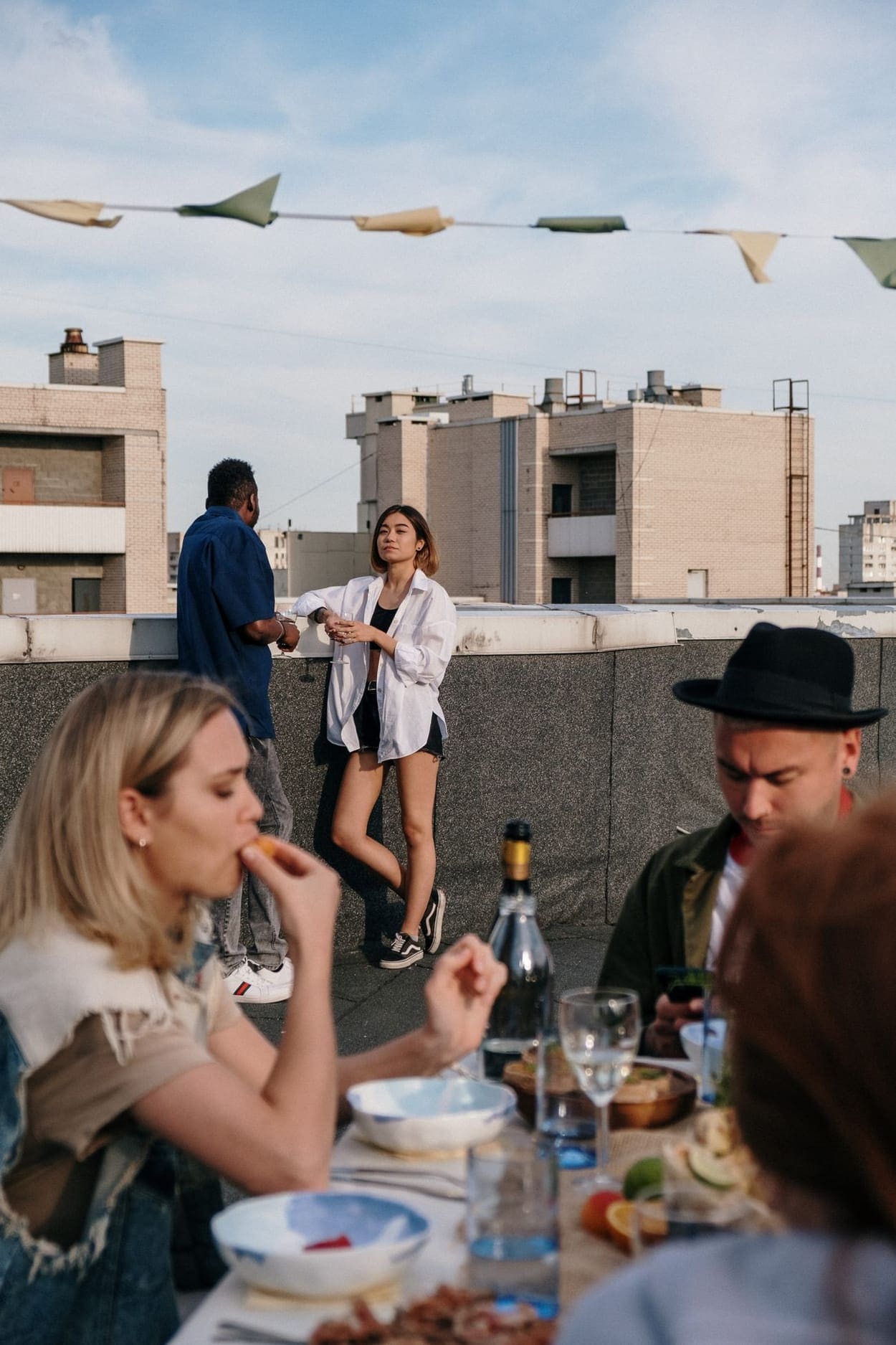 Friends enjoying drinks together on a rooftop at sunset (illustrative photograph)
